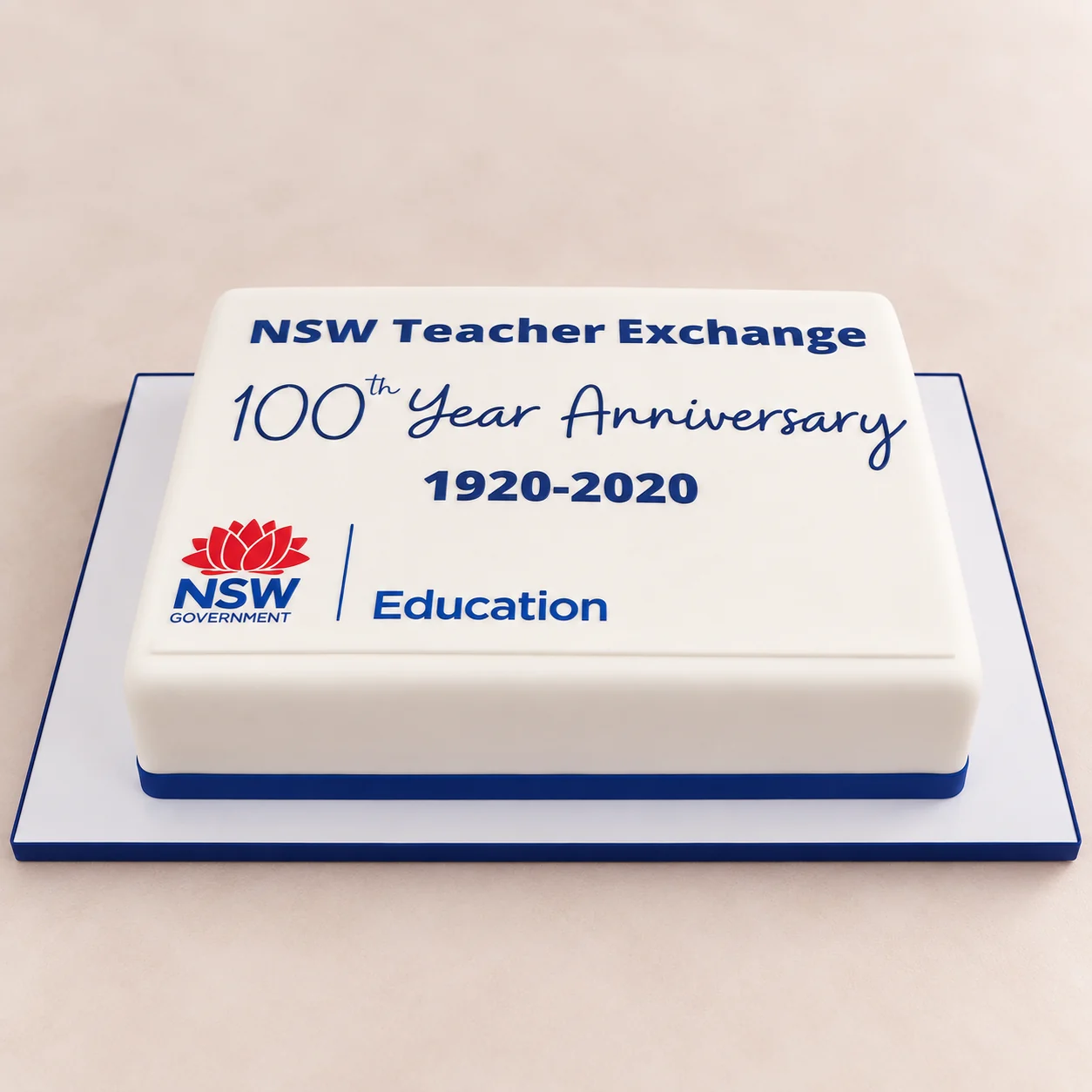 Rectangular NSW Teacher Exchange 100th year anniversary cake with NSW Education branding